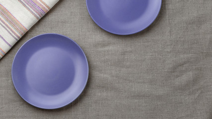 Empty purple plate on burlap background