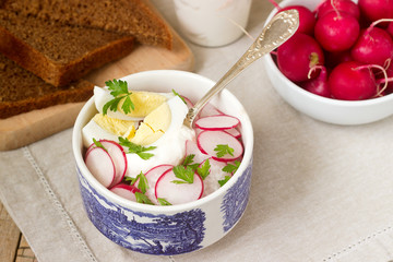Salad with radish, egg and sour cream, served with rye bread. Rustic style.