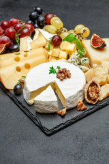 various types of cheese on stone serving board