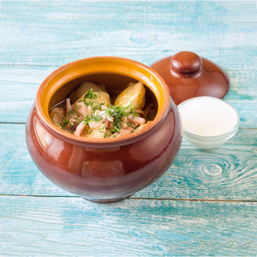 stewed potatoes in a pot on blue wooden background