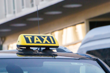 Taxi car on the street at day time,taxi sign on the cab roof while parking on the road waiting for passaenger vintage film photo effect