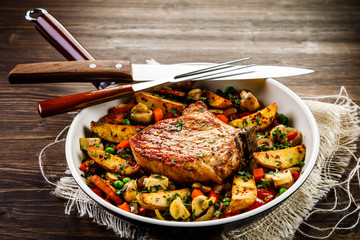 Grilled steak, baked potatoes and vegetables