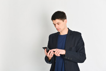 man, student or freelancer in a jacket, emotionally posing with a phone