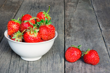 Sweet ripe strawberry on old wooden table. Rustic food photo.