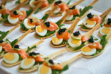 Delicates, appetizer filling with red fish, quail egg, black caviar and lime. Catering service.