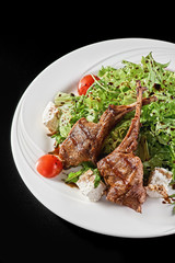 Grilled lamb ribs with onion, salad and sliced tomato