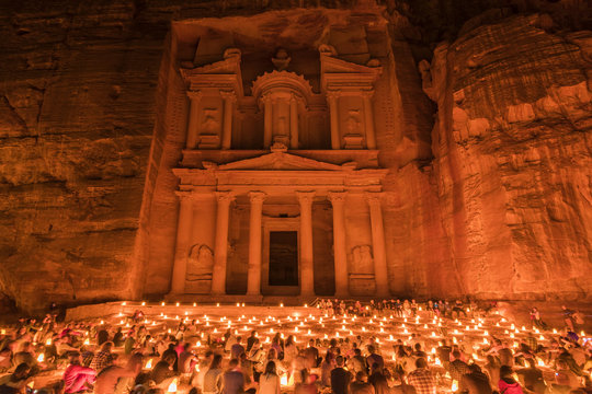 Large Group Of People Sitting On The Ground At Night, The Rock Cut Architecture Of Al Khazneh Or The Treasury At Petra, Jordan.