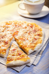 Pizza and Coffee on wooden table, cup of cappuccino.