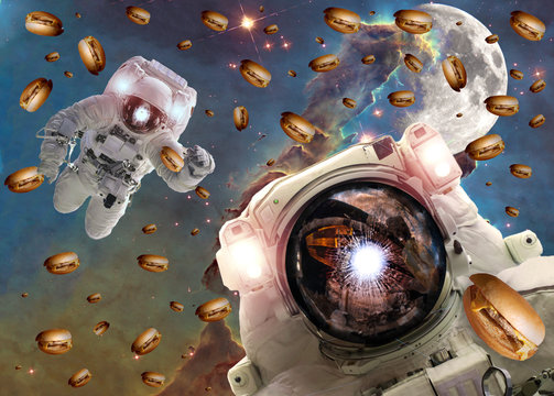 Astronauts in outer space with cheseburgers on the  pillar of creation and the Moon on the background. Elements of this image furnished by NASA