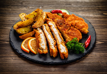 Fried pork chop, baked potatoes vegetables