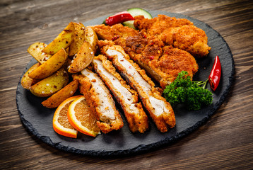Fried pork chop, baked potatoes vegetables