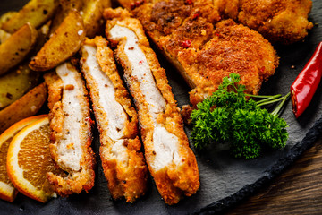 Fried pork chop, baked potatoes vegetables
