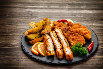 Fried pork chop, baked potatoes vegetables