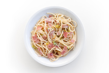spaghetti with ham and courgette flowers, top view of the plate on white background