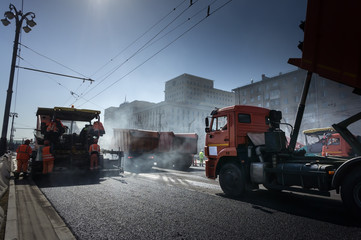 Road repair, compactor lays asphalt. A lot of heavy special machines