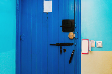 Blue door with various locks and wall with cards and switch in a three stars hotel