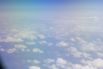 Fototapeta na wymiar White clouds in the sky are photographed at the height of the flight of the aircraft