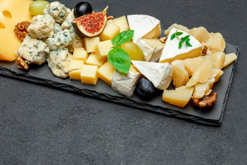 various types of cheese on stone board