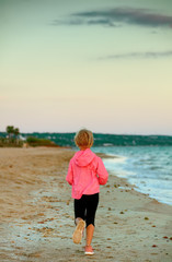 Fototapeta na wymiar healthy child on seashore in evening running
