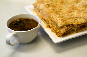 Delicious Napoleon cake with french creme patissiere on white plate with cup of coffee