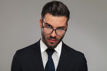 portrait of sensual businessman looking over glasses