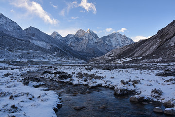 Creek in Pheriche valley after snowfall with Kangtega in the background, Nepal