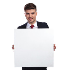portrait of businessman holding a white empty billboard