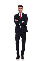 happy businessman standing with arms folded