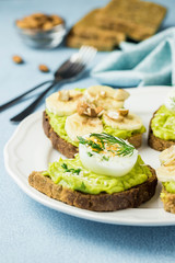Toasted bread with avocado, eggs, banana and nuts. Selective focus, space for text, close up.
