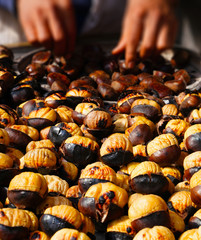 Man grilling chestnuts for sale on street
