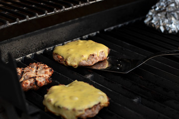 Burgerpatties are grilled on the grill with cheese