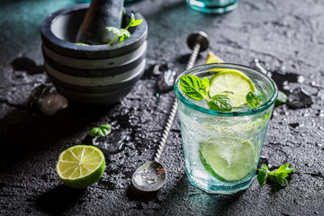 Tasty Mojito with lime and mint on black rock