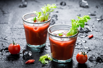 Bloody mary cocktail with chili peppers on black rock