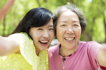 happy senior mother and daughter taking selfie