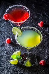 Cold Margarita with fresh fruits on black rock