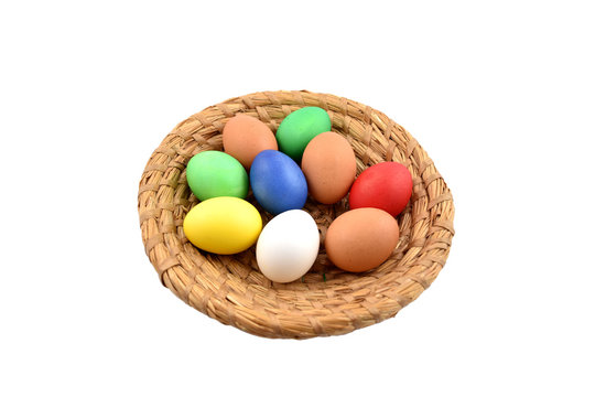 Basket with colored eggs stock images. Easter basket on a white background. Easter decoration photo. Wicker basket with egg. Easter concept
