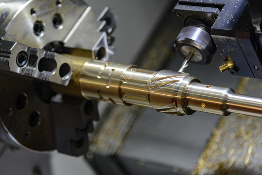 The CNC turning or lathe machine cutting groove slot at the brass shaft by the milling spindle.