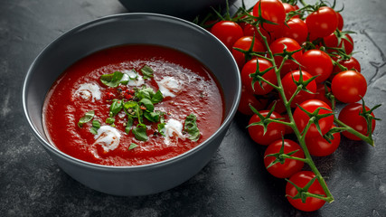 Tomato and fresh basil soup with garlic, cracked papper corns, served with cream and sourdough bread