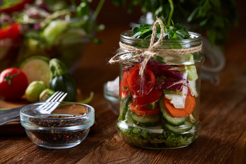 Fresh vegetable salad and ripe veggies on cutting board over wooden background, close up, selective focus