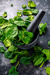 Fresh organic spinach leaves in marble pestle ready for pesto making