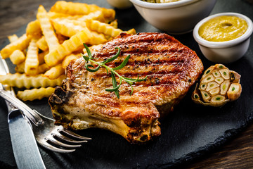 Fried pork chop, French fries and vegetable salad