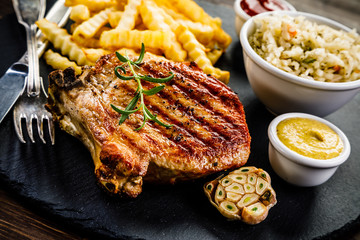 Fried pork chop, French fries and vegetable salad