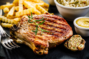 Fried pork chop, French fries and vegetable salad