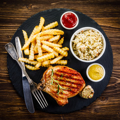 Fried pork chop, French fries and vegetable salad