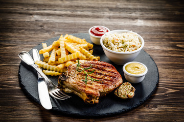 Fried pork chop, French fries and vegetable salad
