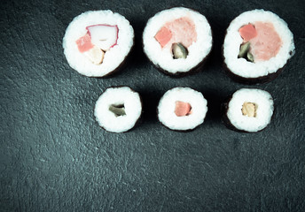 Obraz na płótnie Canvas Various kinds of sushi on the dark background.