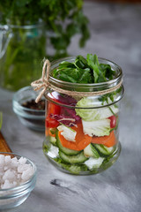 Fresh vegetable salad and ripe veggies on cutting board over white background, close up, selective focus