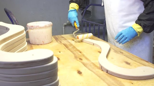 Industrial carpenter worker varnishing on wood