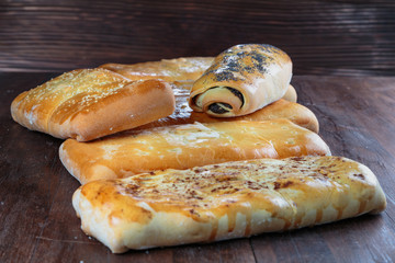 yummy freshly baked pies are laid out on a dark wooden surface