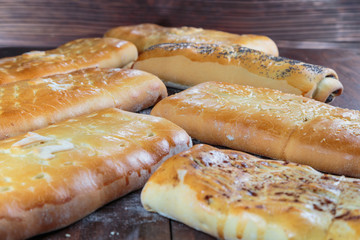 yummy freshly baked pies are laid out on a dark wooden surface